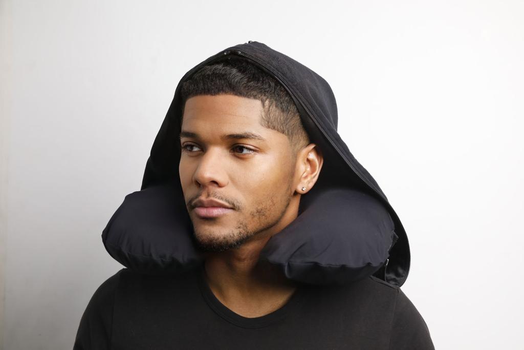 Guy wearing a black hooded neck pillow